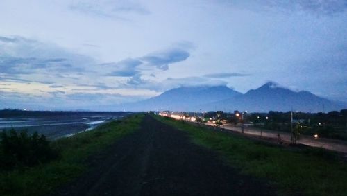 Road by landscape against sky