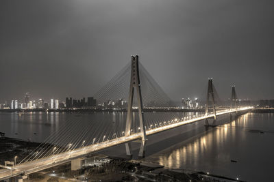 Bridge over river in city at night