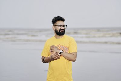 Young man using phone while standing on land