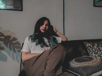 Young woman sitting on sofa at home