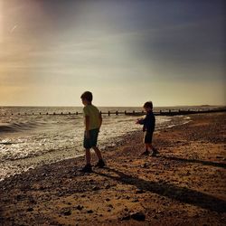 Rear view of boys playing on beach