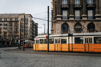 Railroad tracks by buildings in city against sky