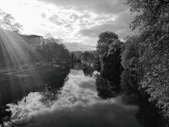 Canal amidst trees against sky