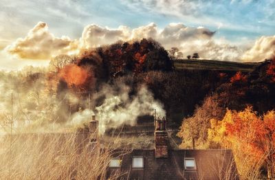 Panoramic view of trees and buildings against sky during autumn