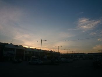 Cars on road against sky during sunset