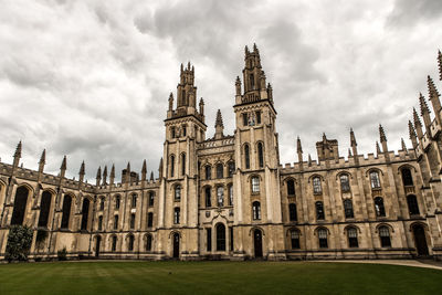 Low angle view of buildings against cloudy sky