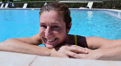Portrait of smiling woman in swimming pool on sunny day