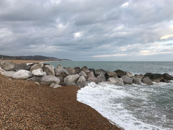 Rocks on sea shore against sky