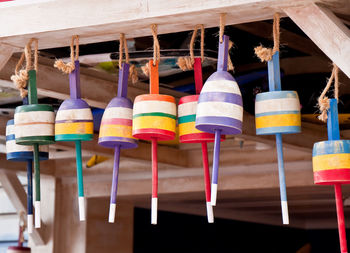 Close-up of multi colored bouys hanging on rope and wood