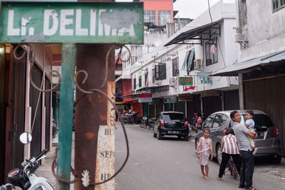 People on street against buildings in city