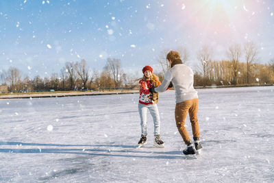 Full length of woman walking on snow covered field