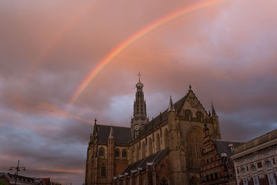 Low angle view of rainbow over cityscape against sky