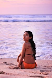 Portrait of young woman sitting at sea 