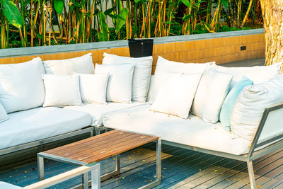 Empty chairs and table against plants