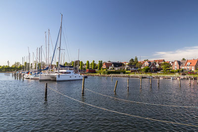 Sailboats in river against sky