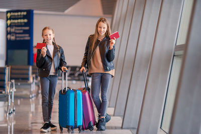 Sisters holding passport while standing at airport