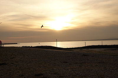 Scenic view of beach against sky during sunset