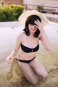 Young woman wearing black bikini in swimming pool