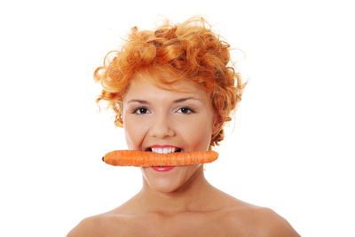 Portrait of shirtless man eating face against white background