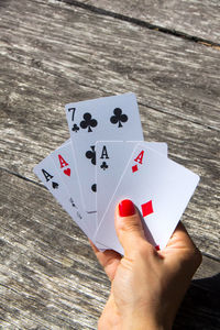 Cropped hand of woman playing cards at table