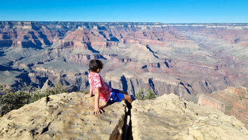 Rear view of woman standing on rock