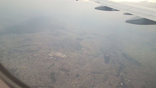 Aerial view of airplane wing over landscape