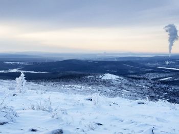 Scenic view of snow covered land against sky
