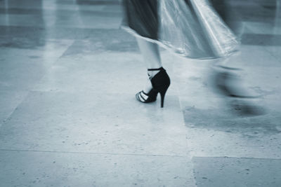 Low section of woman dancing on tiled floor