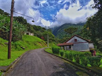 Road amidst trees against sky