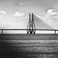 Suspension bridge over sea against sky