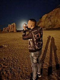 Full length of man standing against illuminated street light