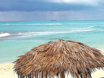 Close-up of parasols on beach against sky