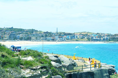 High angle view of city by sea against sky