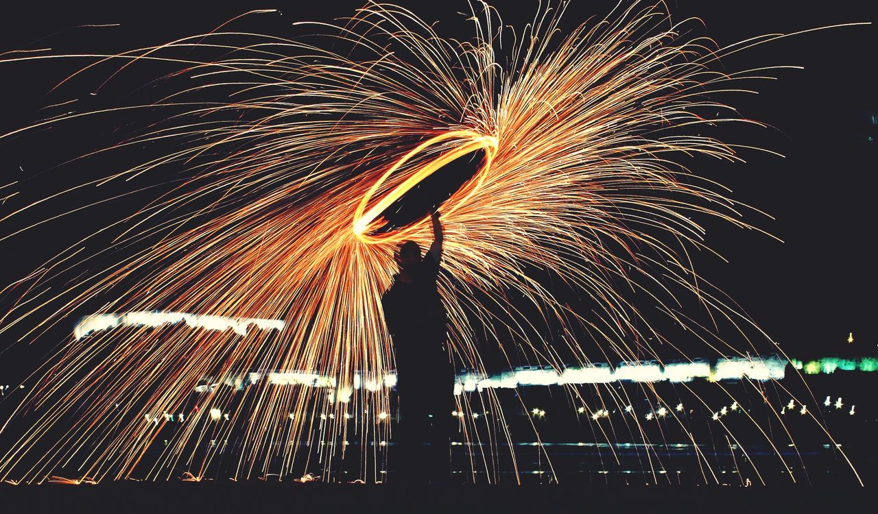 night, illuminated, long exposure, motion, blurred motion, sparks, firework display, light trail, arts culture and entertainment, speed, glowing, exploding, firework - man made object, spinning, firework, celebration, event, outdoors, lighting equipment