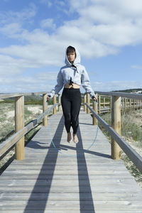 Asian chinese woman jumping rope barefoot in sunny day