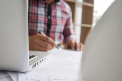 Midsection of man using laptop