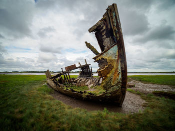 Abandoned truck on field against sky