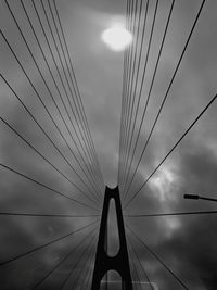 Low angle view of silhouette man standing by bridge against sky
