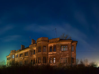 Low angle view of old spooky building against sky at night