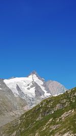 Scenic view of snowcapped mountains against clear blue sky