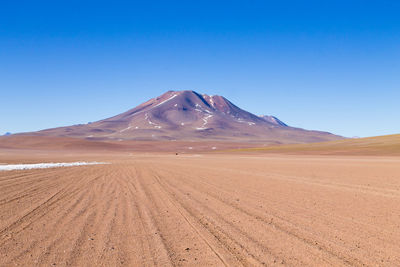 Scenic view of desert against clear blue sky