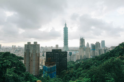 Buildings in city against cloudy sky