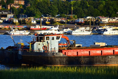 Boats moored at harbor against sky