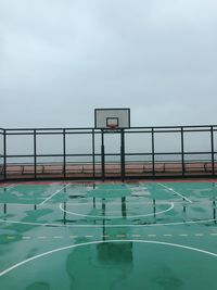 View of basketball hoop by sea against sky