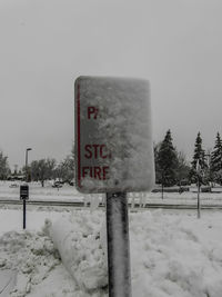 Information sign on snow covered field against clear sky