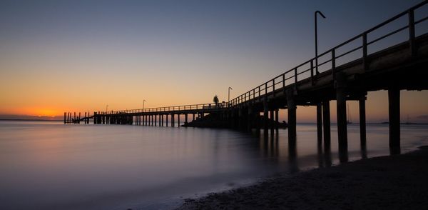 Pier on sea at sunset