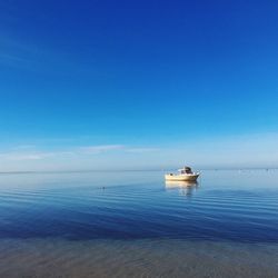 Lone boat in calm blue sea against sky