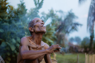 Side view of shirtless man looking away