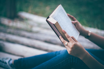 Midsection of woman reading book