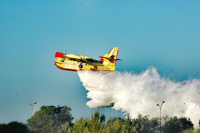 Low angle view of airplane flying against sky